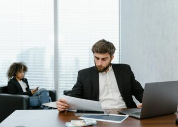 Employees in a corporate office reviewing job loss reports in the crypto industry.