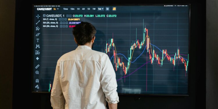 A trader analyzes tokenized equities on a digital trading platform, with charts and data displayed.