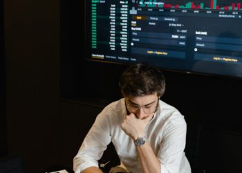 Traders monitor Bitcoin prices on screens in a financial office, highlighting ETF market activity.