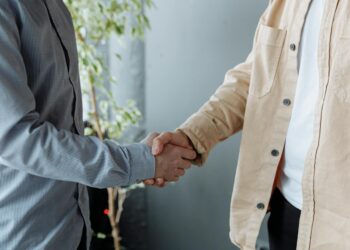 Handshake between businesspeople over a contract, symbolizing a financial agreement in crypto.