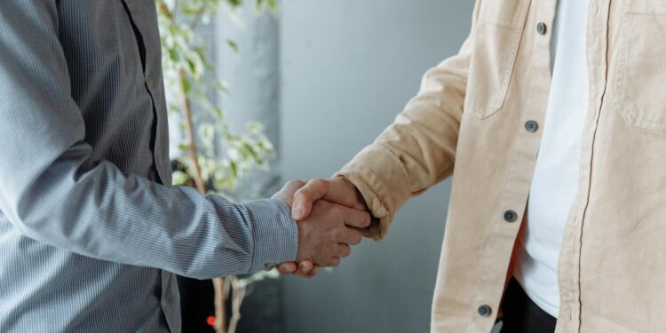 Handshake between businesspeople over a contract, symbolizing a financial agreement in crypto.