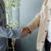 Handshake between businesspeople over a contract, symbolizing a financial agreement in crypto.