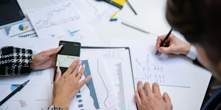 A diverse group of professionals collaborates over blockchain graphics and financial data charts.