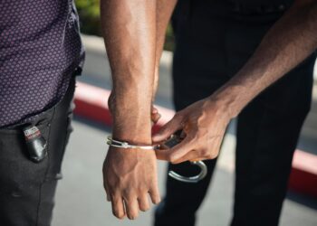 Law enforcement officers detain a suspect in a cryptocurrency-related kidnapping case.