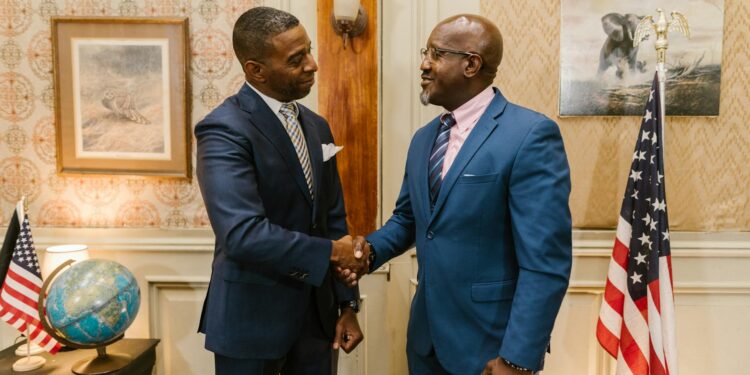 Two officials shaking hands, symbolizing collaboration in cryptocurrency regulation.