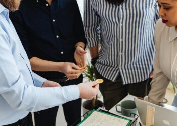 A diverse group of investors discusses cryptocurrency investment strategies in an office setting.