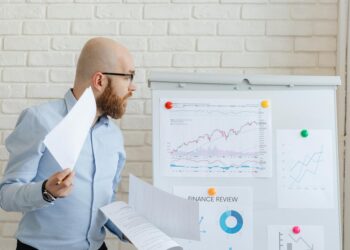 A financial analyst reviews documents on proposed Basel III changes affecting cryptocurrency regulations.