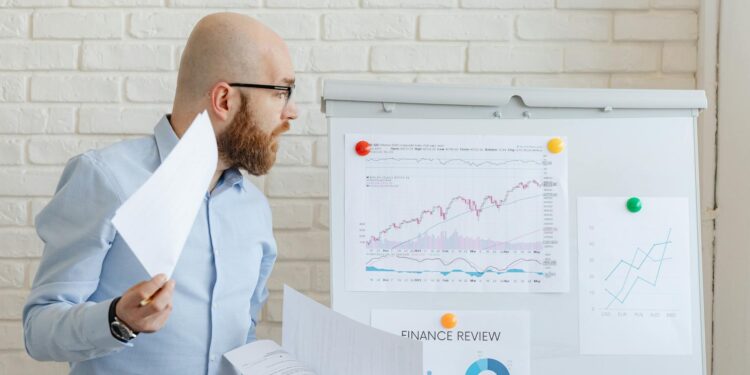 A financial analyst reviews documents on proposed Basel III changes affecting cryptocurrency regulations.