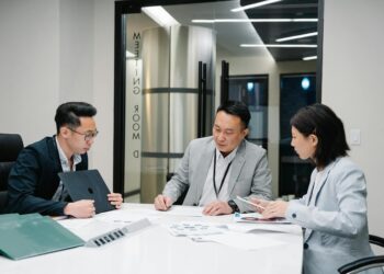 Businesspeople discussing cryptocurrency strategies in a modern office setting.