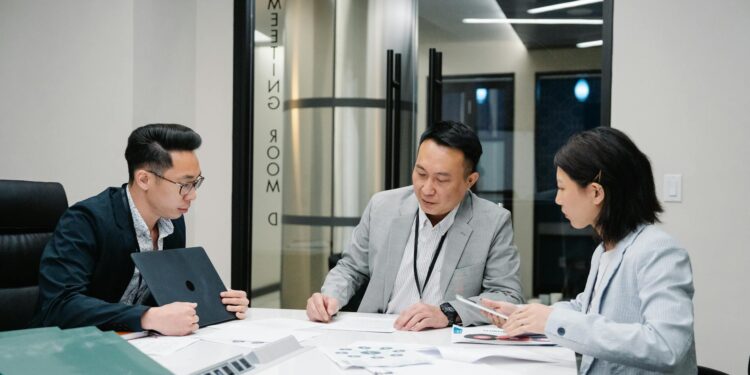 Businesspeople discussing cryptocurrency strategies in a modern office setting.