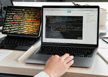 A developer works on a laptop displaying cryptocurrency exchange interface and code.