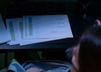 A financial analyst reviewing cryptocurrency audit documents at a desk.