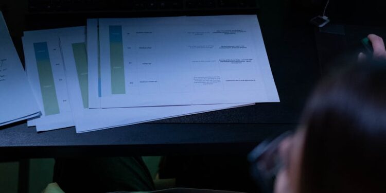 A financial analyst reviewing cryptocurrency audit documents at a desk.