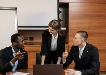 Group of people in suits discussing cryptocurrency regulations in a conference room.