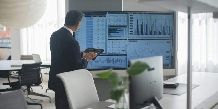 A financial analyst examines Bitcoin charts and ETF data in a modern office setting.