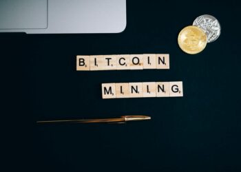 Bitcoin mining rigs illuminated in a dark room, showcasing cryptocurrency operations.