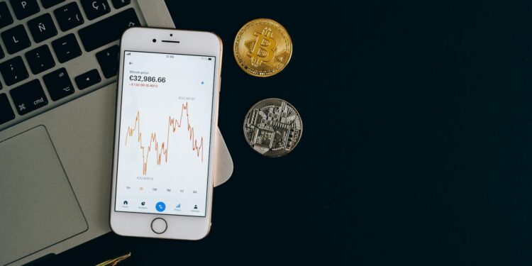 A close-up of Bitcoin and Ethereum coins with fluctuating stock market graphs in the background.
