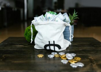 Cryptocurrency coins on a table with a blurred background of financial documents.