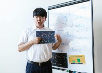 Business people discussing cryptocurrency investment with Bitcoin graphics and financial charts.