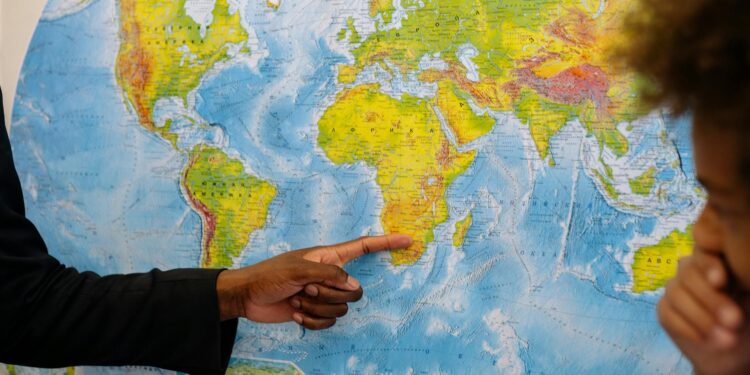 Falling Bitcoin chart juxtaposed with world map highlighting geopolitical tensions.