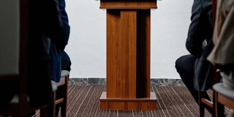 SEC Chair speaking at a podium, discussing crypto regulation and safe harbor for firms.