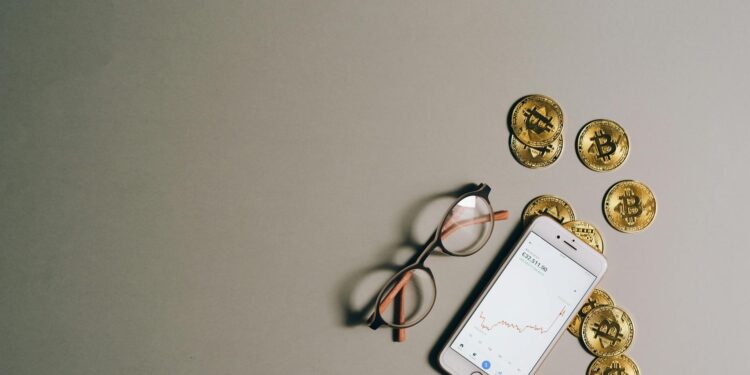 Bitcoin coins stacked with a fluctuating stock market graph in the background.