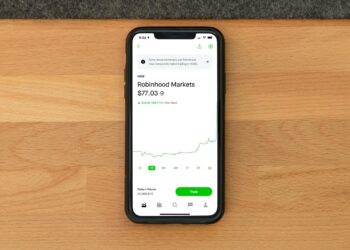 A stock market graph showing a downward trend with Robinhood's logo overlaid.