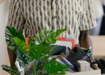 Employees leaving the Epic Games office, carrying personal belongings amidst layoffs.