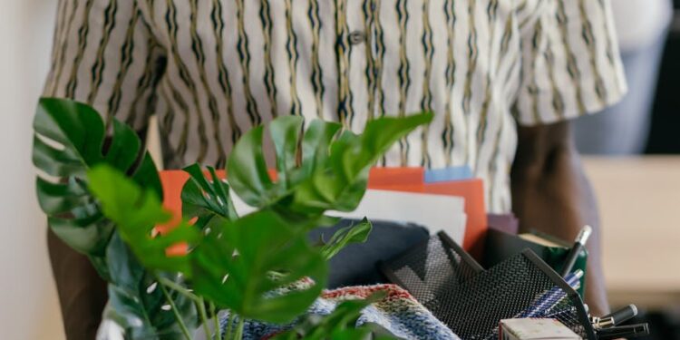 Employees leaving the Epic Games office, carrying personal belongings amidst layoffs.