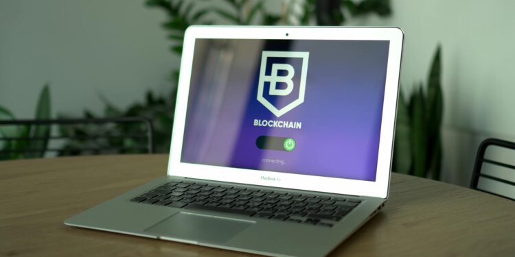 A developer analyzing code on a laptop with blockchain graphics in the background.