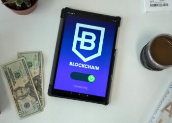 Stacks of US dollars next to a smartphone displaying a cryptocurrency wallet app.