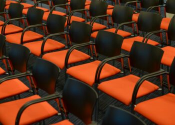Crypto conference venue with empty seats and a calendar showing 2027.