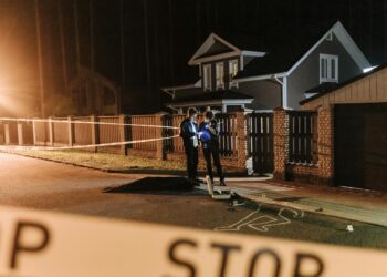 A city skyline with police tape and investigators examining a crypto office.