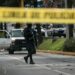 Police at a crime scene near a school, investigating a recent shooting incident.