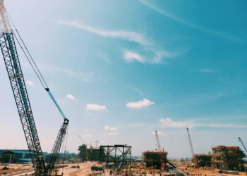 Construction site of a large data center with heavy machinery and cranes for expansion project.