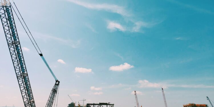 Construction site of a large data center with heavy machinery and cranes for expansion project.