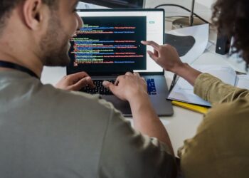 A diverse team collaborates at a computer, showcasing Dreamspace's no-code Web3 tool.