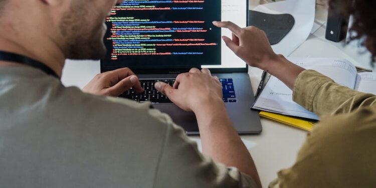 A diverse team collaborates at a computer, showcasing Dreamspace's no-code Web3 tool.