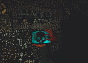 A hacker's silhouette with cryptocurrency symbols, highlighting cybersecurity threats.