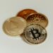 Cryptocurrency coins and a house model, symbolizing crypto real estate investment.