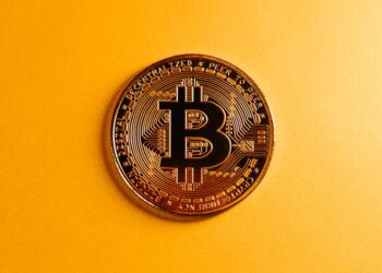 A tanker in the Strait of Hormuz with Bitcoin logos overlaying the scene, symbolizing crypto commerce.