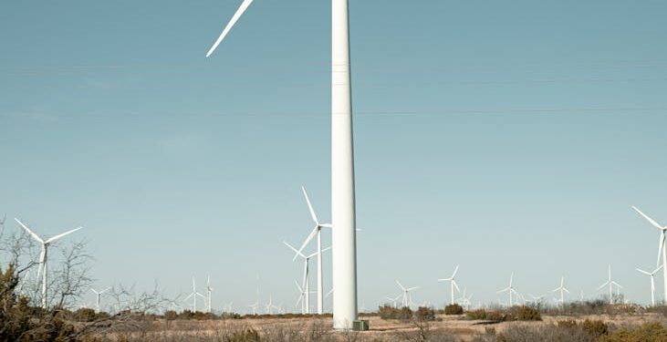 Wind turbines surround a sprawling data center building in Texas, highlighting renewable energy use.