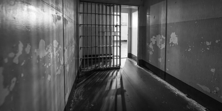 Crowded detention center with somber faces reflecting harsh conditions and reported violations.