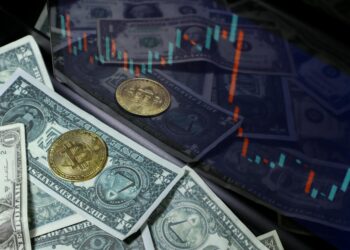 A close-up of a blockchain graphic overlaying a financial chart and dollar bills.