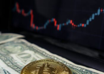 A close-up of a digital dollar coin with financial charts in the background.