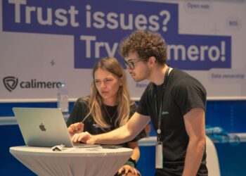 Cybersecurity professionals discussing OpenAI's new suite for partners in a tech conference setting.