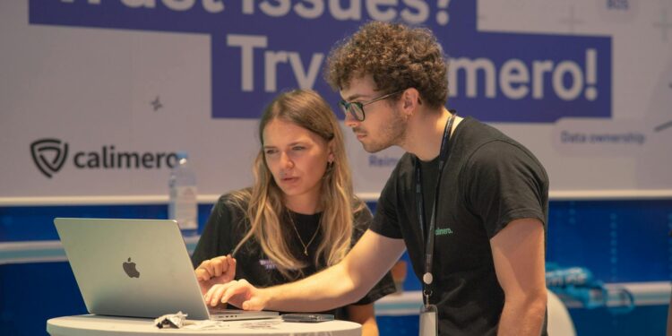 Cybersecurity professionals discussing OpenAI's new suite for partners in a tech conference setting.