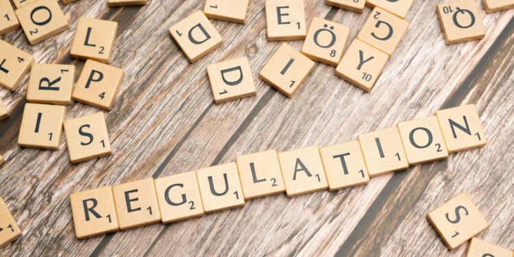 A digital representation of Bitcoin with regulatory symbols in the background.