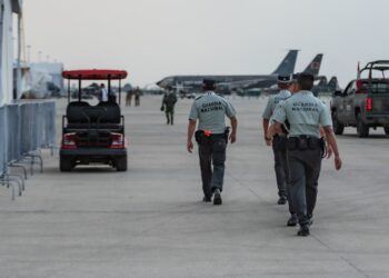 Li Xiong, chair of the Huione Group, escorted by officials at an airport for extradition to China.