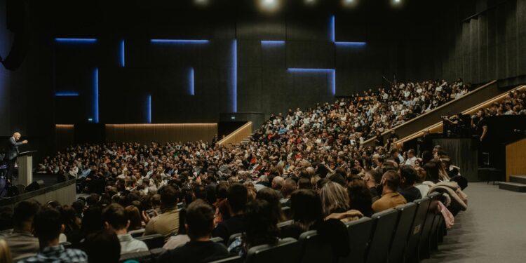 Large crowd at a cryptocurrency conference, with banners promoting Ripple's Swell 2026 event.
